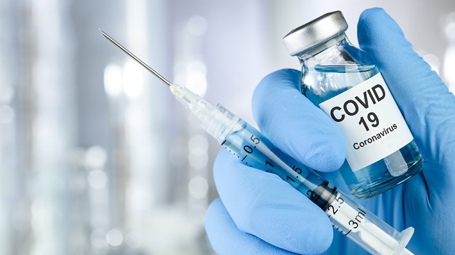 hand holding a Covid-19 vaccine