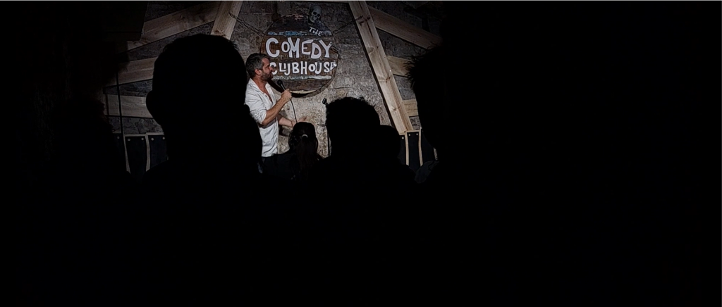 Photo taken at the Comedy Clubhouse during a show, with Matthew performing on stage.
