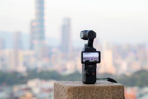 An Osmo Pocket 3 camera recording a city skyline