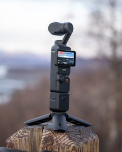 Osmo pocket 3 camera being used with the tripod and the extension of the creator combo to record steady footage